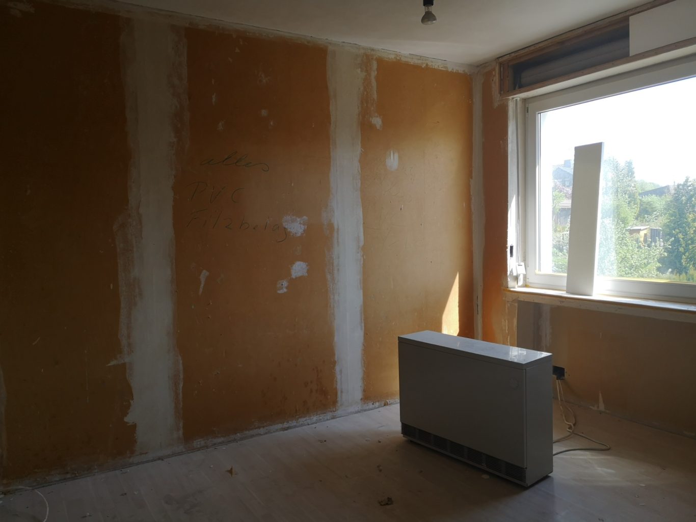 Immobilienmakler Münster Leere Raum mit unvollendeten Wänden und einem Heizkörper unter einem Fenster.