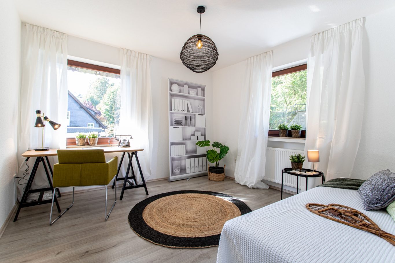 Immobilienmakler Münster Heller, moderner Raum mit Schreibtisch, Pflanzen und natürlichen Materialien.