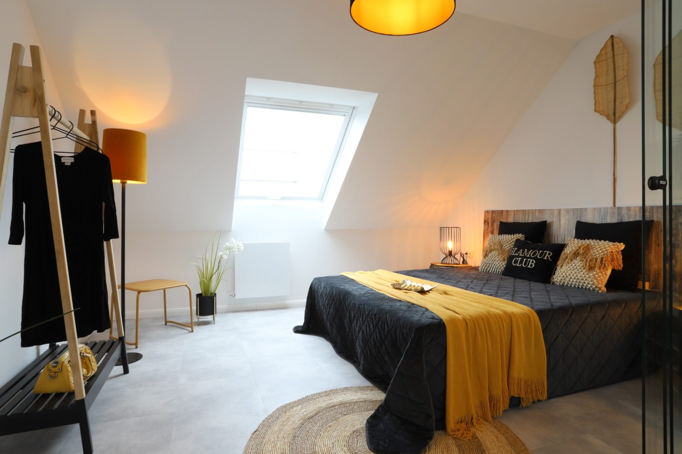 Immobilienmakler Helles Schlafzimmer mit einem Doppelbett, modernen Möbeln und einem Dachfenster.