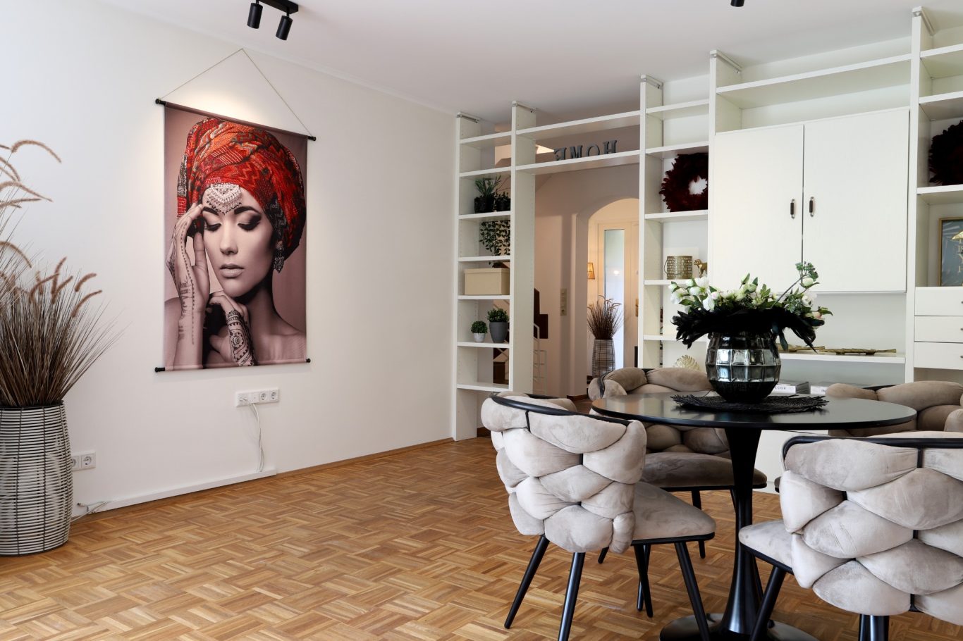 Wohnung Münster Moderne Wohnküche mit einem Porträt einer Frau und eleganten Möbeln.